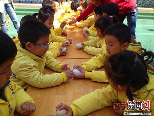 资料图：孩子们进行“斗蛋比赛 。窦跃文 摄